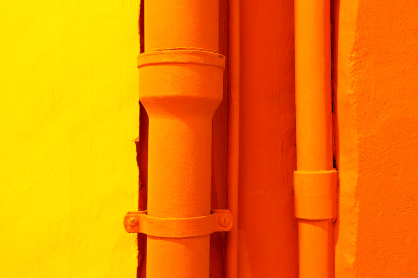 orange pipes next to a yellow wall